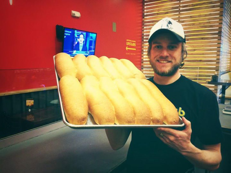 Guy holding tray of bread